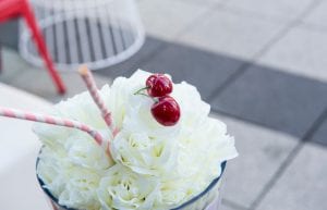 milkshake table centrepiece with flowers and cherry and straw on top lights up from inside