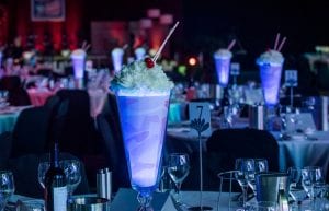 milkshake table centrepiece with flowers and cherry and straw on top lights up from inside