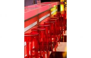 illuminated bar with red and white stripes on front red plastic ghost stools and black and white chequered dance floor