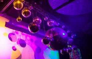 varying sizes of mirror balls from 200mm to 1m hanging at different heights from a ceiling truss