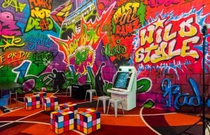 graffiti themed backdrop with old fashioned arcade games and rubix cube designed seats