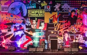 12m wide 1980s eighties backdrop showing various iconic 80s characters such as ghostbusters, star wars, mtv, fame, ET, space invaders