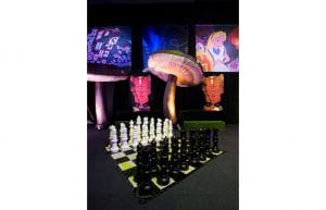 giant chess set on black and white dancefloor. 4m inflatable mushroom props and alice theme backdrops hanging from wall