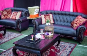 alice in wonderland theme with mad hatter table centrepiece, black sofas, low wooden coffee tables, persian rugs
