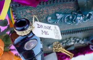 small dark bottle with drink me tag alice in wonderland theme