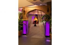 gold arch entry feature for arabian nights themed events. gold dome and palm trees with black cocktail tables