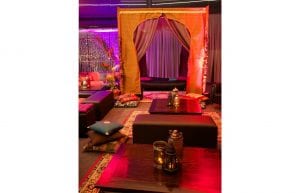 arabian nights themed cocktail event, low wooden tables for chill out area with black bench seats and arabian cushions and rugs and arabian themed chill out cabana hut