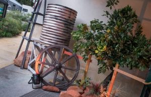 australiana outback themed event water tank wagon wheel fake gum tree and fence posts rocks
