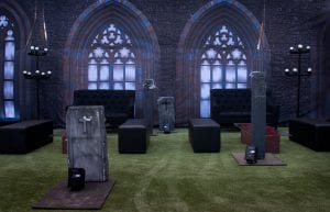 Rocky Horror event theme with coffin coffee table, gothic window drape backdrop, hi back sofas, rectangular ottomans, candelabra, parcan lights, skeletons and cemetery props for hire.