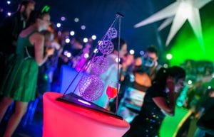 Space event theme with black drapes, led dance floor, giant inflatable stars, illuminated led bar furniture, and tiered wire orb centrepieces for hire