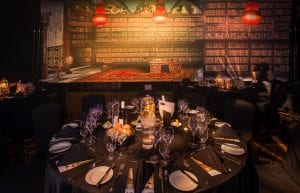 Steam Punk event theme with coloured crystal beaded chandeliers, steam punk library backdrop, cloche dome centrepieces, black chair covers and tablecloths for hire.