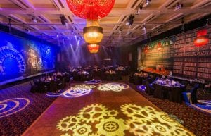 Steam Punk event theme with large gold frames, steam punk prints, crystal beaded chandeliers, steam punk library backdrop, steam punk backdrop, gobos, cloche dome centrepieces, black chair covers and tablecloths for hire.