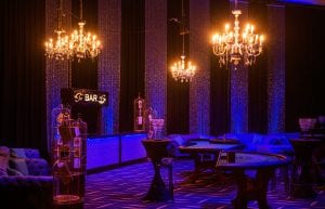 Las Vegas event styling theme with, pressed tin light up bar, velvet sofas, birdcages, lanterns, playing cards, centrepieces, colour beaded chandeliers, cushions, hi bar tales, stools, casino tables, red drapers, illuminated 007 bond props and beaded curtains for hire. Photo taken in Perth for Christmas Party.