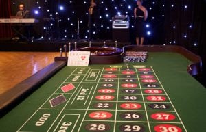 Las Vegas event styling theme with playing cards, casino tables and star cloth backdrop for hire. Photo taken in Perth for Christmas Party.