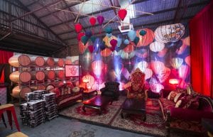 Vietnam Asian event styling theme with, lanterns, Arabian rugs, coffee tables, throne, sofa, cushions, pressed tin bar, stools and lantern backdrop for hire.