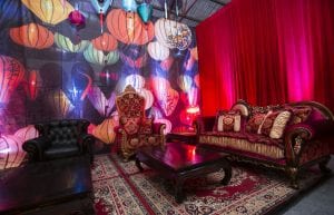 Vietnam Asian event styling theme with, lanterns, Arabian rugs, coffee tables, throne, sofa, cushions, pressed tin bar, stools and lantern backdrop for hire.