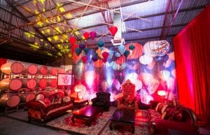 Vietnam Asian event styling theme with, lanterns, Arabian rugs, coffee tables, throne, sofa, cushions, pressed tin bar, stools and lantern backdrop for hire.
