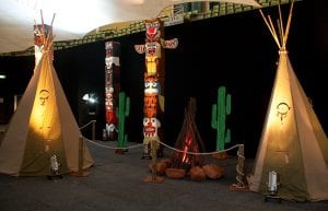 Wild West event styling theme with tee pee tents, fake fire, totem pole props and wild west backdrop for hire