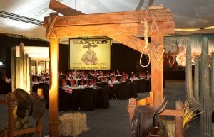 Wild West event styling theme with entry feature, horse saddles, hay barrels, backdrop and chair covers for hire.