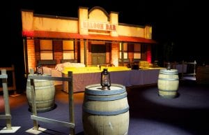 Wild West event styling theme with saloon bar prop , saloon doors, fencing and wine barrels for hire.
